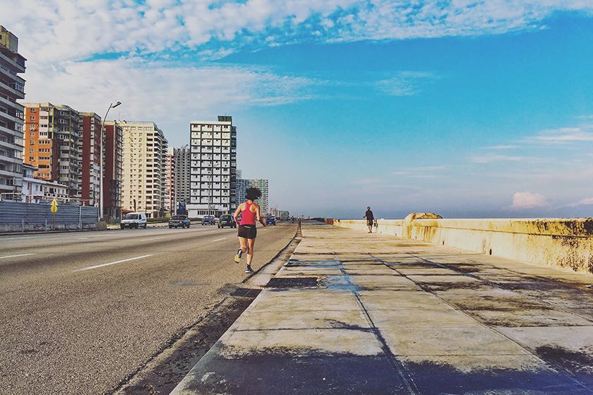 Eine Frau joggt entlang der Malecón in Kubas Hauptstadt Havanna