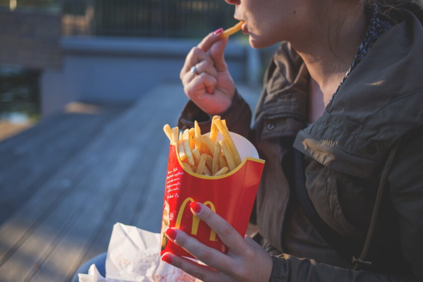 Woman eating french fries.